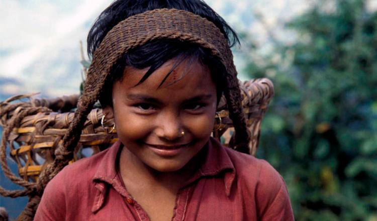 Una niña nepalí transporta productos agrícolas a lo largo de un camino montañoso de 65 km. Foto: FAO/Franco Mattioli 